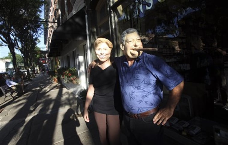 Residents Gary Kiernan, right, and Laurie Bathrick, wear Bill and Hillary Clinton masks while walking in downtown Rhinebeck in upstate New York.